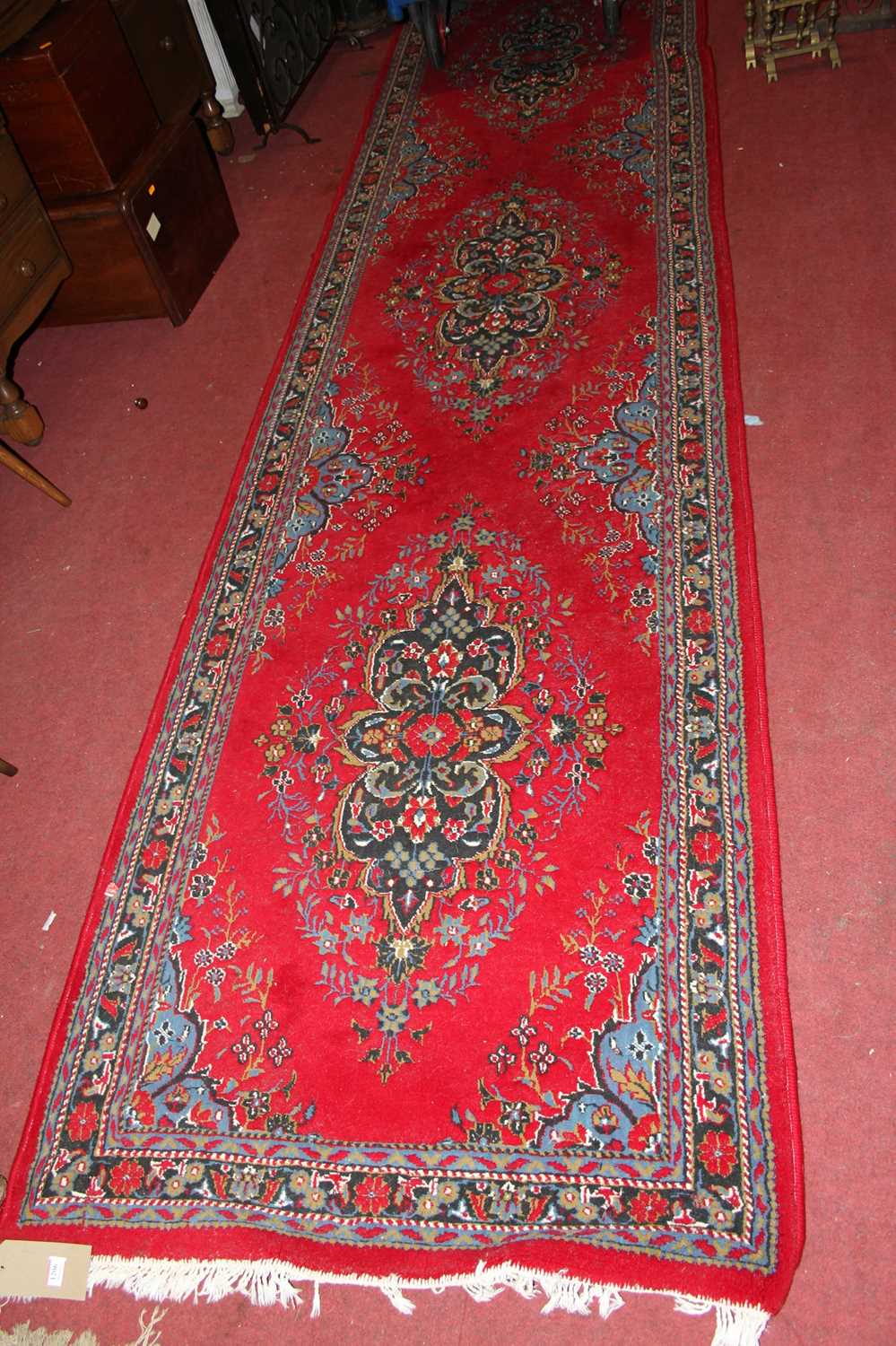 A Persian style red ground woollen Tabriz long hall runner, 395 x 98cm