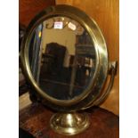 An early 20th century brass circular swing toilet mirror, dia.41cm