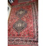 A Persian woollen red ground Shiraz rug, with multiple tramline borders, 205 x 162cm