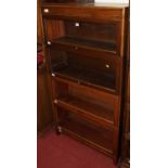A 1930s oak four-tier stacking bookcase, having typical hinged glazed doors, w.86.5cm
