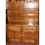 An Ercol mid-elm 'Golden Dawn' kitchen dresser, having a two-tier open plate rack over base fitted