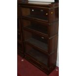 A 1930s oak four-tier stacking bookcase by the Globe Wernicke Company, having typical hinged