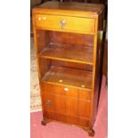 A 1930s oak narrow bookshelf, with single upper drawer over lower cupboard door, w.57cm