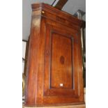 An early 19th century oak and mahogany crossbanded single door hanging corner cupboard; together