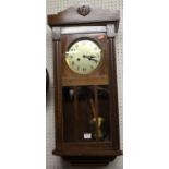 A 1930s walnut droptrunk wall clock, with pendulum and winding key, h.77cm