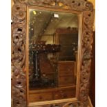 A Continental carved and pierced walnut framed rectangular wall mirror, 95 x 66.5cm