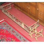 A Victorian wrought iron fender, having scroll decoration, w.127.5cm; together with a pair of late