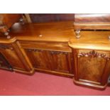 A mid-Victorian mahogany and flame mahogany round cornered inverted breakfront four door