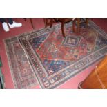 A Persian woollen red ground Tabriz rug (wear and losses, particularly to borders) 206 x 135cm,