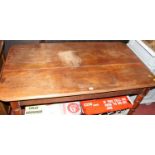 A Victorian faded mahogany round cornered kitchen table, raised on ring turned supports to