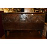 A circa 1700 provincial boarded oak six-plank blanket chest, having a floral line carved front