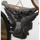 An early 20th century Continental carved and ebonised oak demi-lune wall bracket, modelled as an