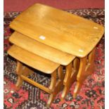 An Ercol mid-elm nest of three occasional tables, the largest w.56cm