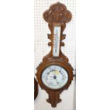 An early 20th century relief carved oak aneroid two-dial wheel barometer