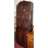 A 19th century mahogany, satinwood inlaid and further strung bowfront bookcase cupboard, having twin