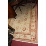 A Persian style machine woven cream ground rug, 240 x 175cm