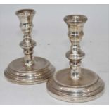 A pair of Elizabeth II filled silver dwarf table candlesticks, each on knopped stem to a domed