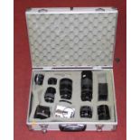 A photographer's hard case containing a collection of vintage camera lenses
