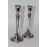 A pair of mid-20th century silver table candlesticks, each having a single sconce to a tapering stem