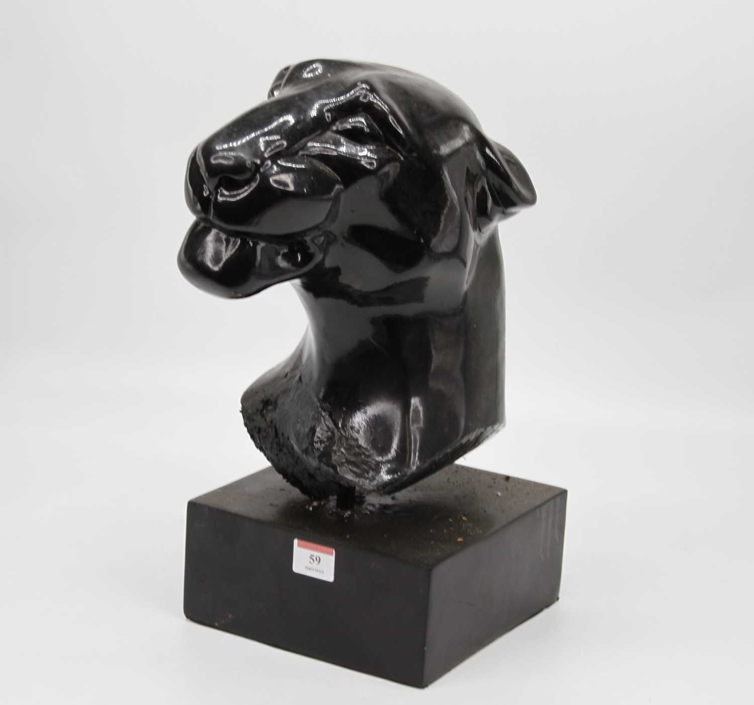 A black painted composite head of a jaguar mounted on a square plinth, height 39cm