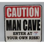 A cast iron sign inscribed 'Caution Man Cave, Enter at Your Own Risk', 25x25cm