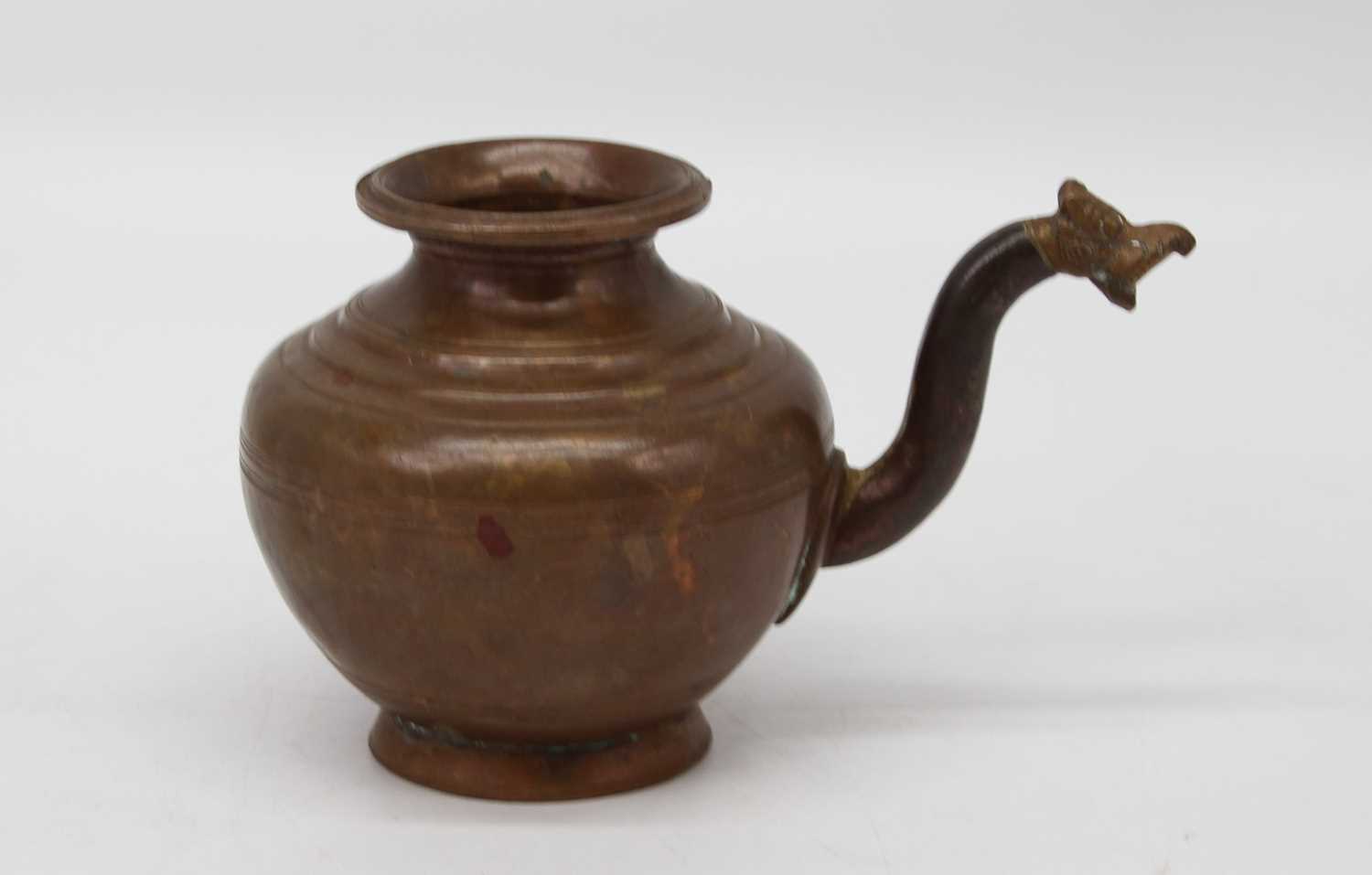 An Indian copper lota water pitcher, having a zoomorphic handle, height 11cm