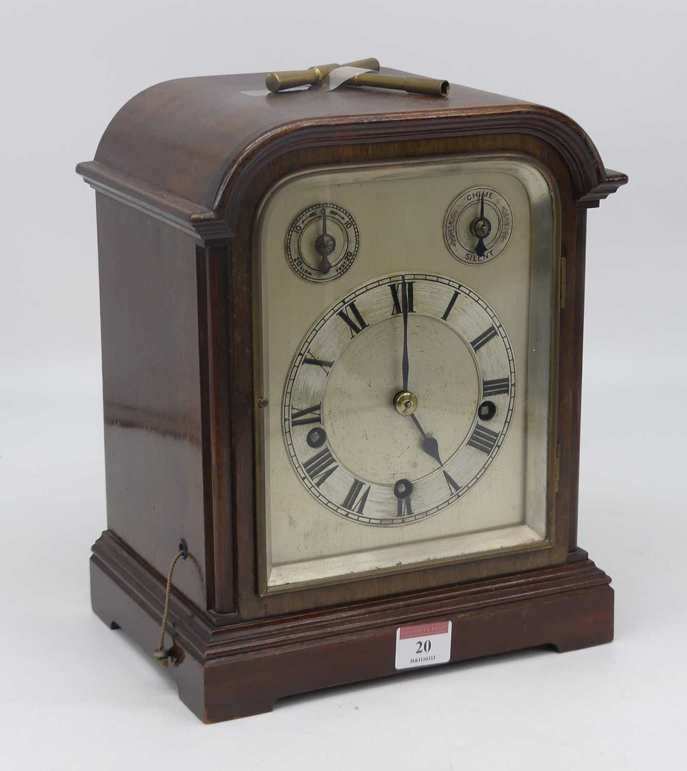 An early 20th century mahogany eight day mantel clock, the silvered dial showing Roman numerals with