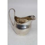 A George III Exeter silver cream jug, of helmet shape, having engraved monogram, maker probably