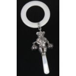 A George V silver babies rattle, in the form of a bear with two bells, suspended from a faux ivory