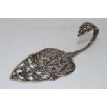 An early 20th century Dutch silver cake server, the shaped blade embossed with a tavern scene with