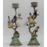 A pair of continental porcelain and gilt metal table candlesticks, each in the form of a bird