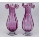 A pair of Victorian style amethyst glass vases, each having a frilled rim, height 36cm
