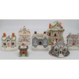 A collection of seven Staffordshire pastille burners and money boxes, each in the form of a cottage,