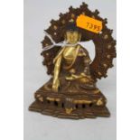 A gilt brass figure of a Tibetan deity in seated lotus pose, having impressed flower mark verso,
