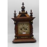 An early 20th century walnut cased eight day mantel clock, the dial showing Roman numerals, height