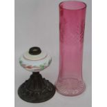 A Victorian copper oil lamp base, having a milk glass font, together with a cranberry glass vase,