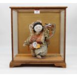 A Japanese doll, in a glazed display case, width 33cm