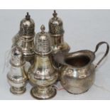 A George V silver cream jug, together with a pair of George V silver pedestal pepperettes, and two