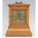 An Edwardian oak three-glass mantel clock, the 5" square brass signed by the retailer Fraser of