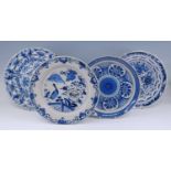 A Delft blue and white charger, 18th century, decorated with flowers, dia.35.5cm, together with