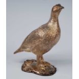 A contemporary silver-gilt grouse, naturalistically modelled with chased detail and standing upon