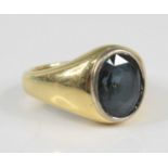 An 18ct yellow gold and sapphire signet ring, the oval faceted sapphire in a white bezel setting,