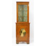 A Sheraton Revival painted satinwood freestanding corner cabinet, having glazed upper section, the