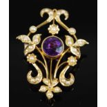 An Edwardian yellow metal amethyst and seed pearl openwork pendant brooch, comprising a central