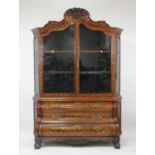 A late 19th century Dutch walnut and floral marquetry bookcase on chest, having a swept pediment