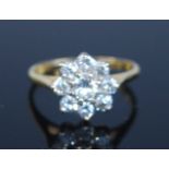 An 18ct yellow and white gold diamond flower shaped cluster ring, featuring nine round brilliant cut