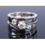 Three white metal diamond stacking rings, each with a round brilliant cut diamond claw set within