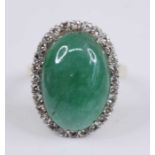 An 18ct yellow and white gold, jadeite and diamond oval cluster ring, featuring a centre cabochon