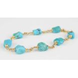 A yellow metal turquoise bracelet, having eight rough turquoise stones alternating with 2.25mm round