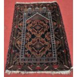 A Persian woollen prayer rug, the blue ground decorated with geometric motifs within multiple